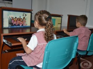 Dos niños usando un computador.