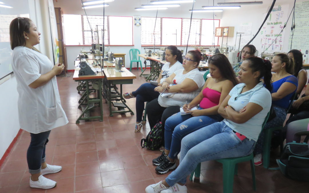 Grupo de mujeres sentadas recibiendo clase.