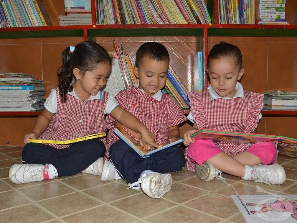 Tres niños leyendo libros