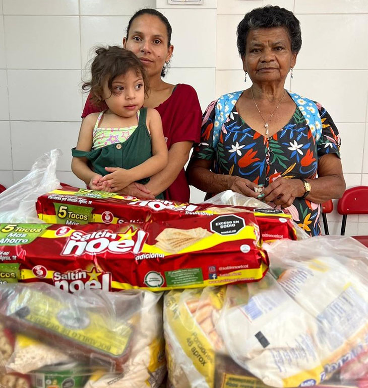 Varios niños sonrientes sosteniendo donaciones