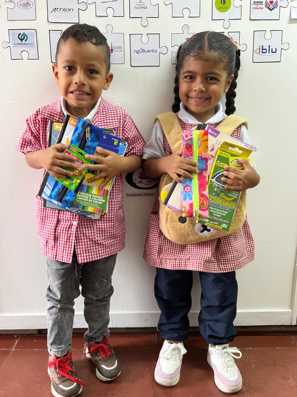 Cuatro niños abrazados mirando la cámara sonrientes