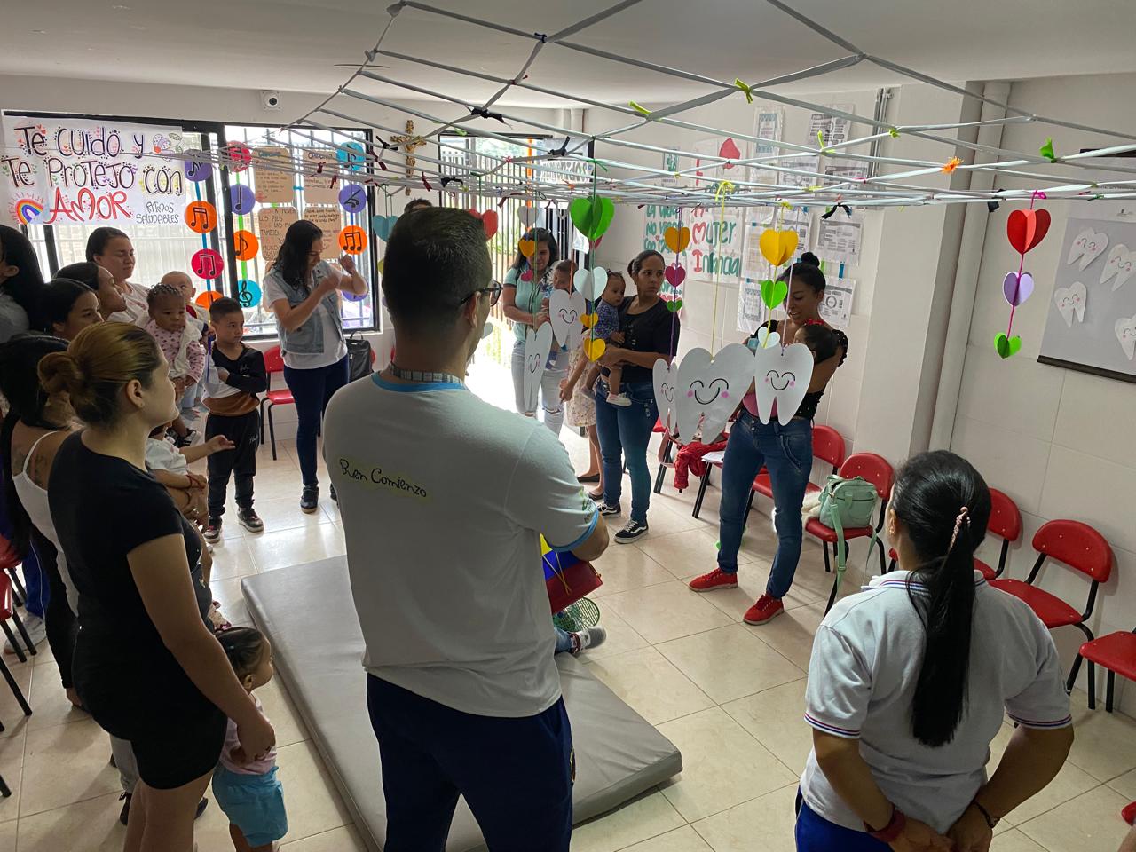 Grupo de madres y sus hijos reunidos y aprendiendo de la clase dictada por la profesora.